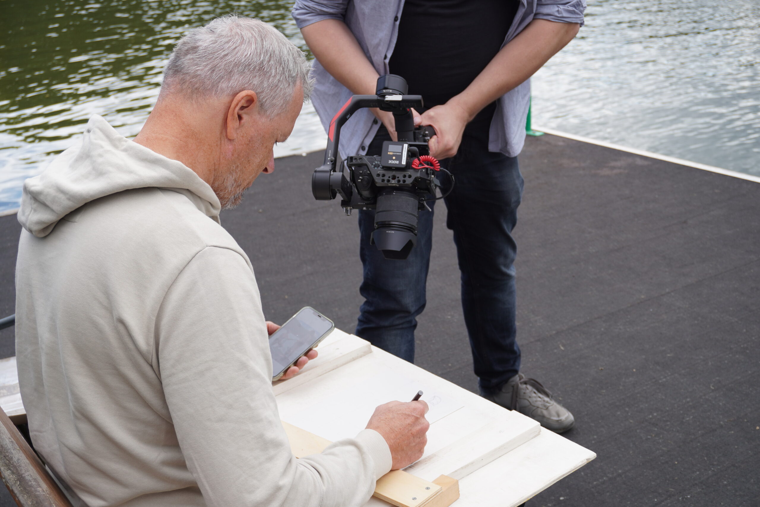 Eine Person wird beim Zeichnen von einer Videokamera gefilmt