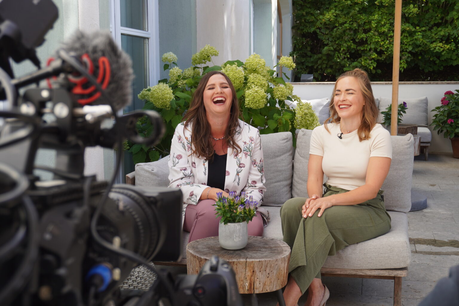 2 personen sitzen vor der kamera und lachen