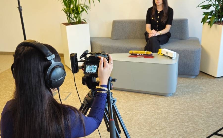 eine person filmt eine andere, die auf einer couch sitzt